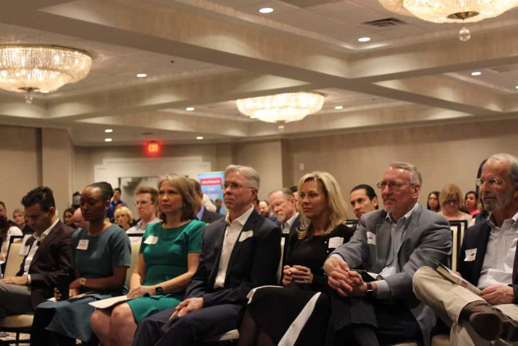 Attendees listening to MC Shankar Poncelet discussing the evening's schedule.