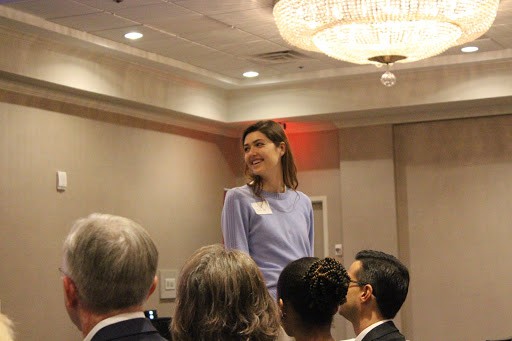 Student activist, Sarah Blakemore, from UT Austin stands as Dr. Marty Makary acknowledges her efforts while speaking.