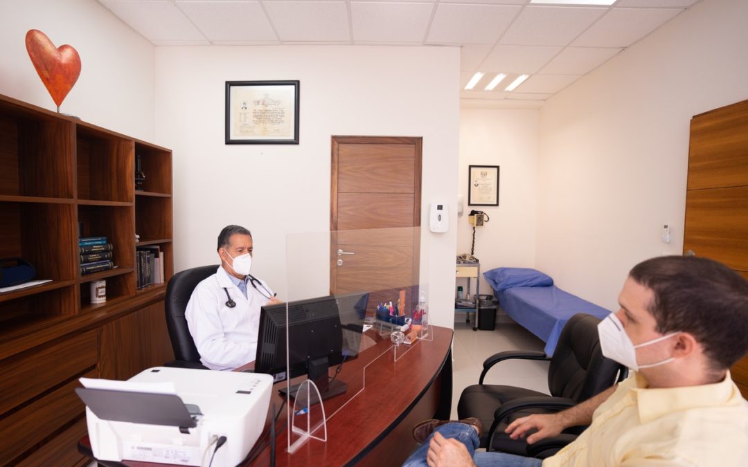 doctor at desk with patient in masks